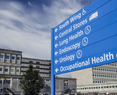 Sign with pointing to various areas of the hospital